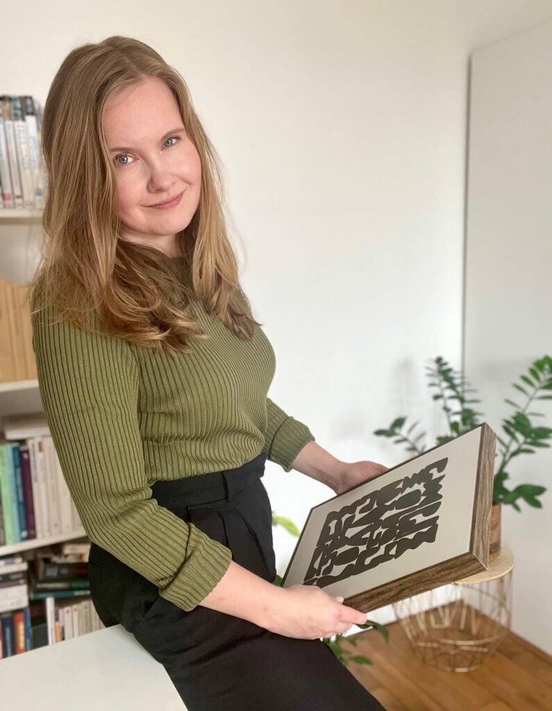 Portrait of dr. Ewelina Chwiejda, founder of Art Wanderer, holding a work of art