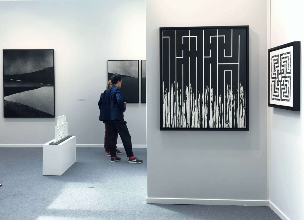 Visitor observing artworks in a gallery — art history learning and visual literacy.