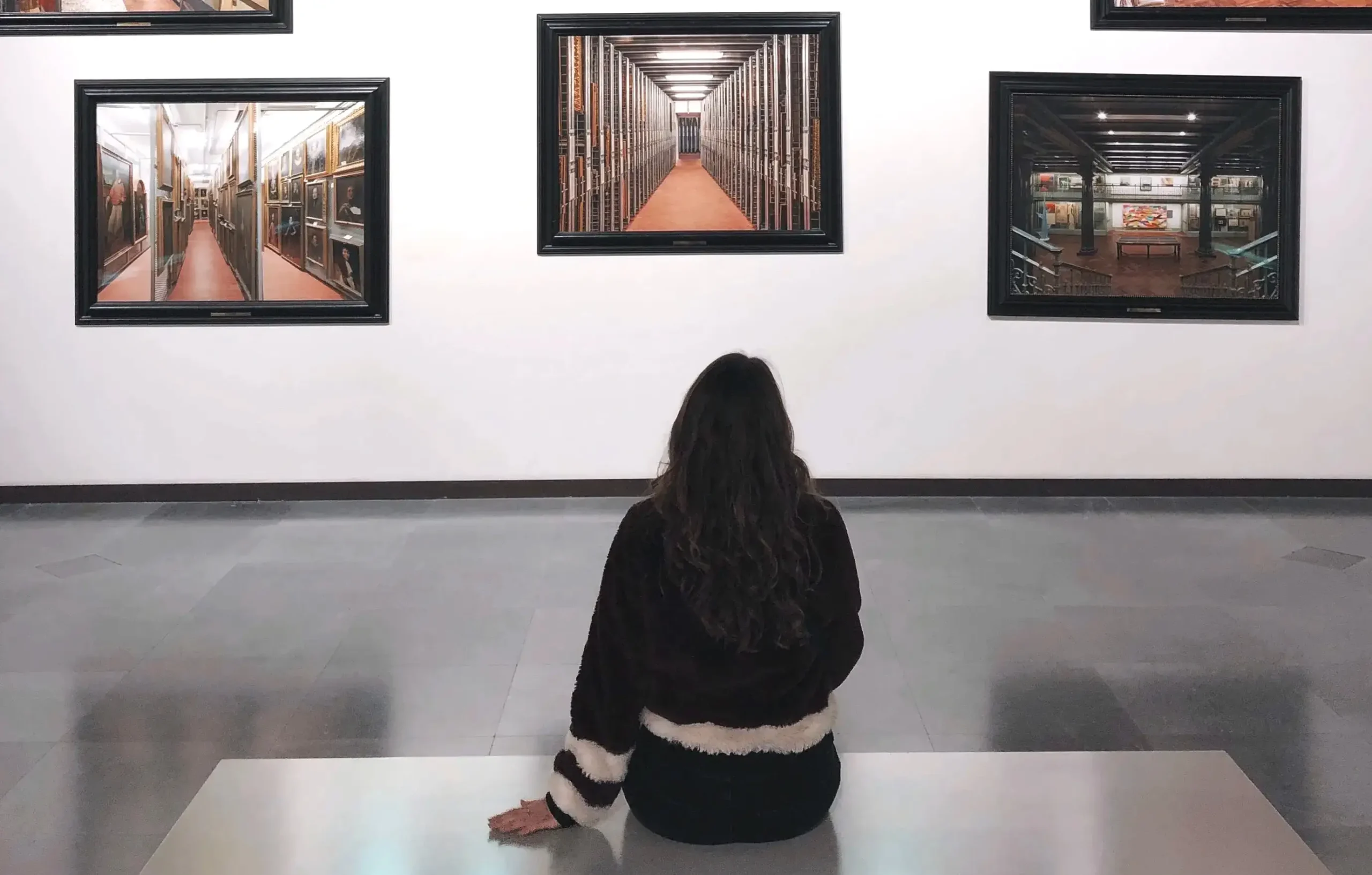 A woman quietly viewing a painting in a gallery.