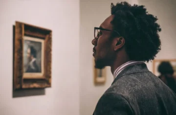 Person mindfully viewing a masterpiece in a gallery to regain focus.