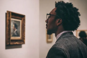 Person mindfully viewing a masterpiece in a gallery to regain focus.